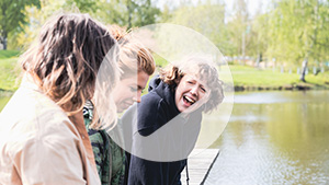 Skrattande studenter vid campusdammen